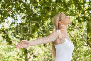 Attractive blonde woman practicing yoga in a park