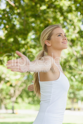 Side view of cheerful attractive woman doing yoga spreading her