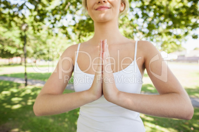 Mid section of content calm woman meditating in a park