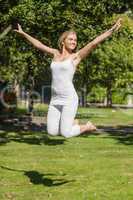 Cheerful young woman jumping in a park