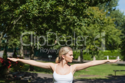 Young woman doing yoga spreading her arms