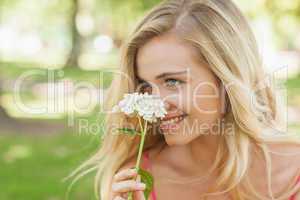Content young woman smelling a white flower