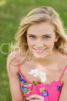 High angle view of lovely young woman holding a white flower