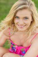 Portrait of attractive young woman sitting on a lawn