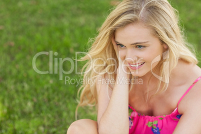 Content cute woman sitting on a lawn