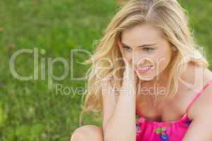 Content cute woman sitting on a lawn