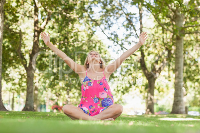 Cheerful blonde woman relaxing on a lawn