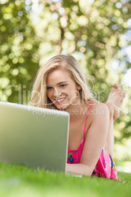 Amused young woman using her notebook