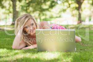 Beautiful blonde woman posing lying on a lawn
