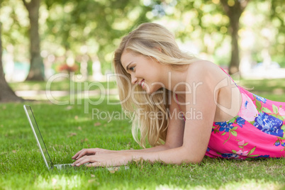 Amused blonde woman working with her notebook