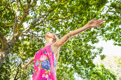 Low angle view of young blonde woman standing on a lawn