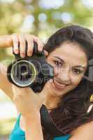 Happy attractive woman holding her camera