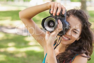 Cute brunette woman taking a picture with her camera