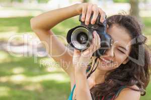 Cute brunette woman taking a picture with her camera
