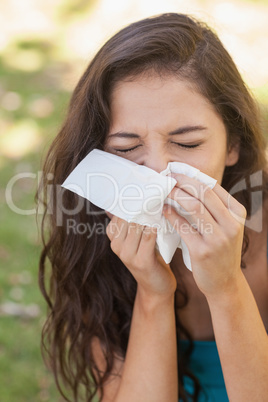Sick brunette woman using a handkerchief
