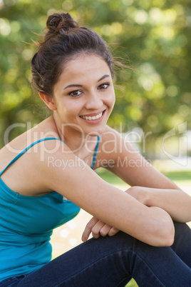 Beautiful young woman sitting on a lawn