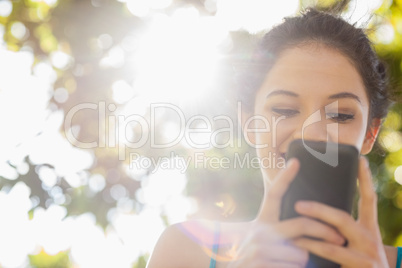 Happy brunette woman texting with her smartphone