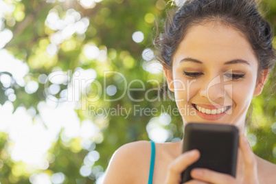 Cheerful woman texting with her smartphone