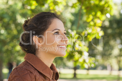 Side view of cute brunette woman wearing a brown coat