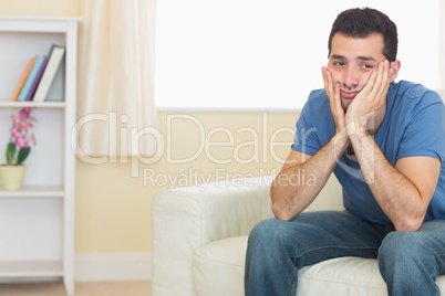 Casual upset man sitting on couch