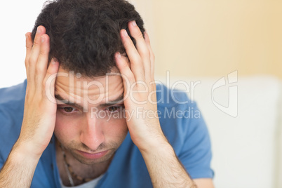 Casual troubled man sitting on couch