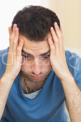 Casual depressed man sitting on couch