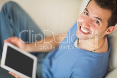 High angle view of casual smiling man using tablet sitting on co