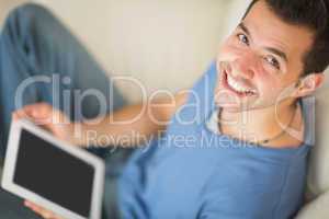 High angle view of casual smiling man using tablet sitting on co