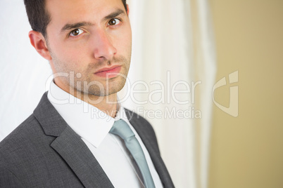 Handsome unsmiling businessman looking at camera