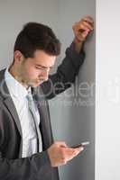 Handsome serious businessman looking at smartphone