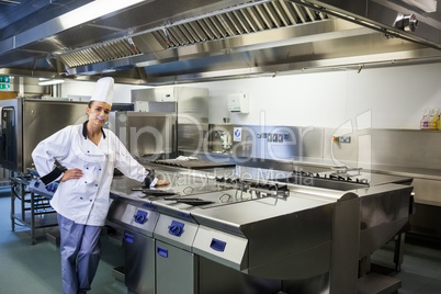 Young content chef standing next to work surface