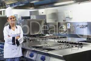 Young smiling chef standing next to work surface