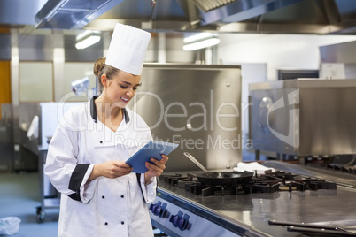 Young happy chef using tablet