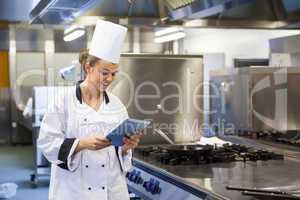 Young happy chef using tablet