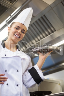 Young cheerful chef holding tray
