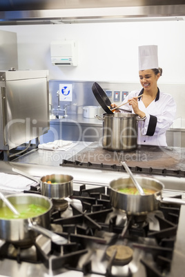 Young cheerful chef preparing meal