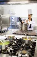 Young cheerful chef preparing meal