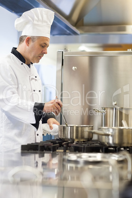 Concentrating head chef stirring in pot