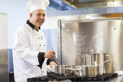 Smiling head chef stirring in pot