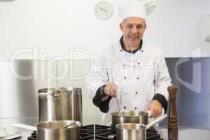 Smiling head chef holding ladle looking at camera