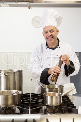 Smiling head chef using pepper mill