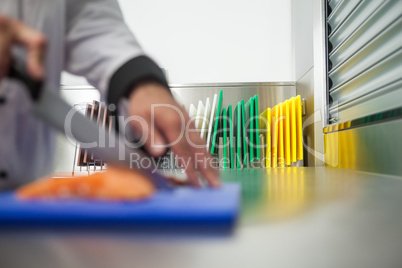 Chef cutting raw salmon with knife