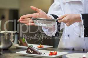 Female chef finishing a dessert plate