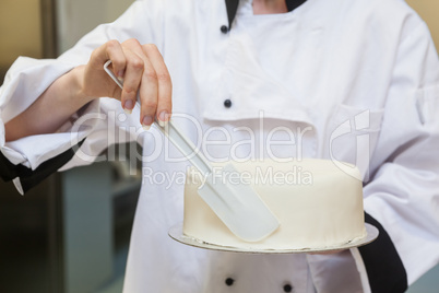 Chef finishing a cake with icing