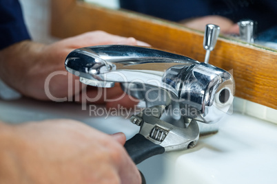 Close up of plumber repairing tap