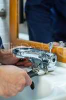 Close up of plumber checking tap