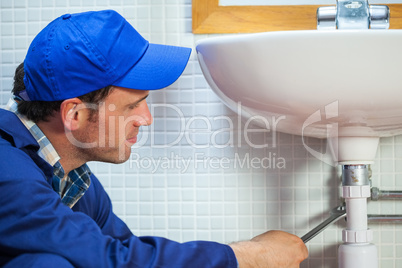 Attractive plumber repairing sink