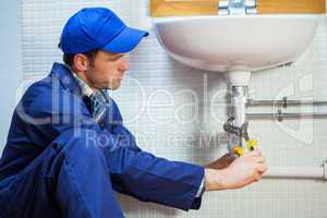 Attractive focused plumber repairing sink