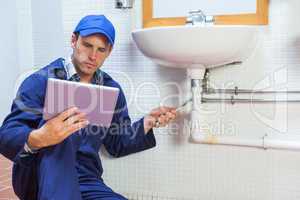Serious plumber consulting tablet
