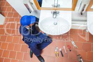 Plumber with cap repairing sink
